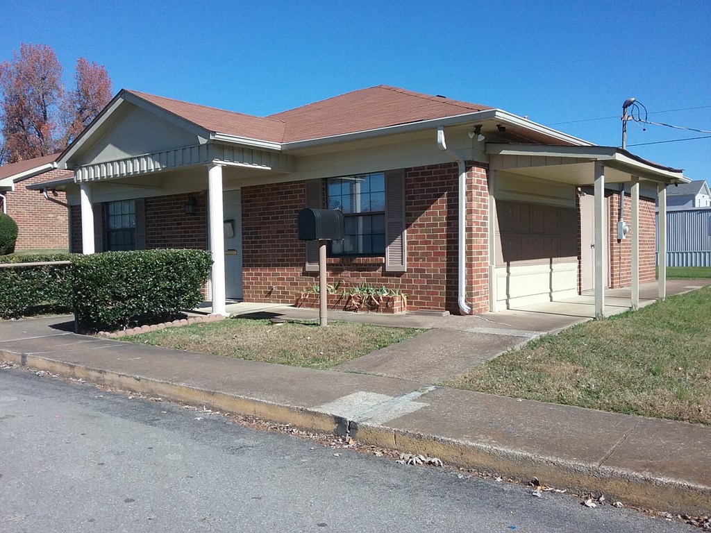 a small brick house with a mailbox in front of it